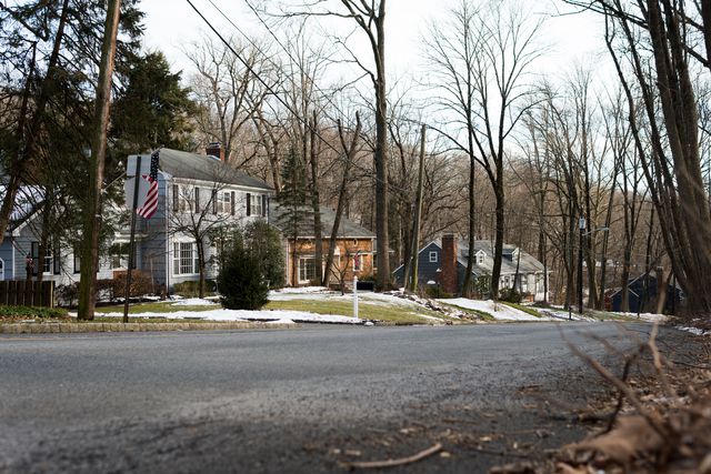Classic architecture houses by Glenside Ave in Scotch Plains, New Jersey. Next to Watchung Reservation. Empty street; no people, no traffic. Cloudy day in winter, Trees without leaves.